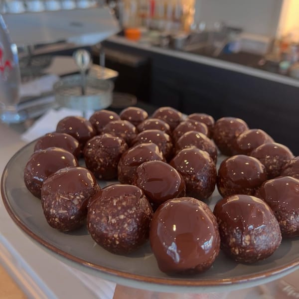 A plate of chocolate-covered energy bites with a cafe counter in the background at Fora Cafe.